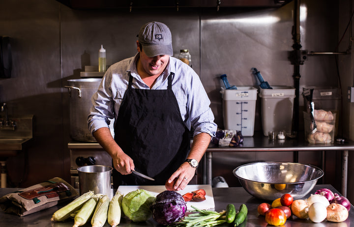 Man in kitchen slicing vegetables