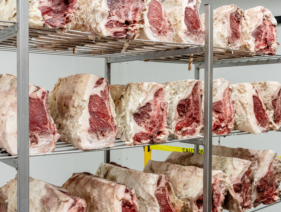 Dry-aging facility interior with beef on metal racks