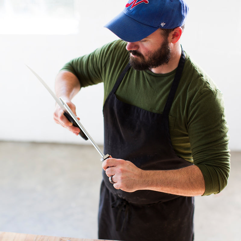 Butcher honing a knife with a sharpening steel